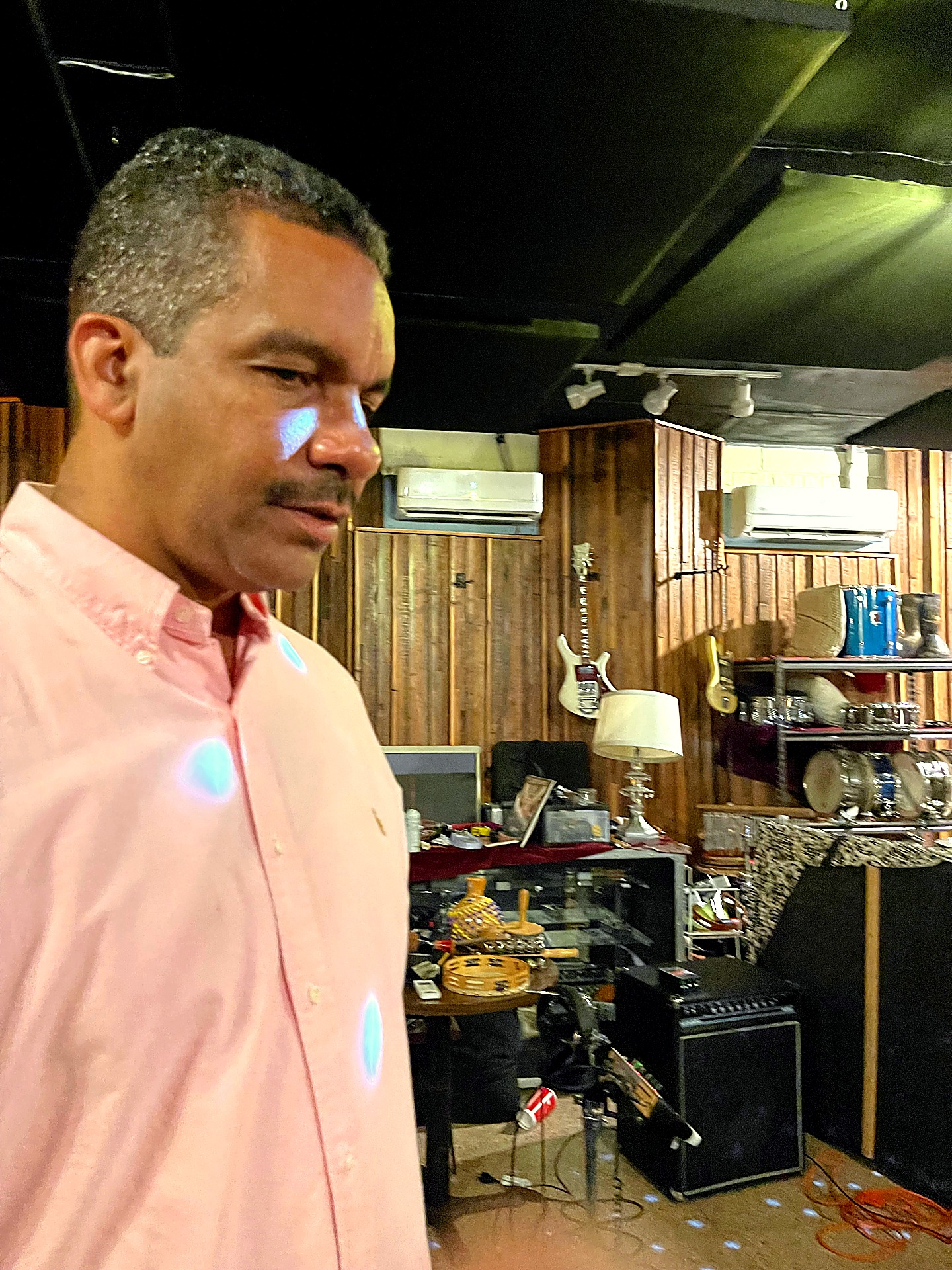 The instrument wall — a working museum of the New Orleans rhythm section.