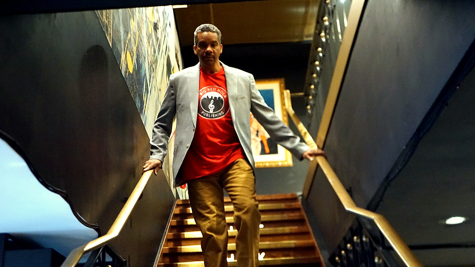 Cyril Darensbourg ascending a New Orleans staircase in editorial wardrobe