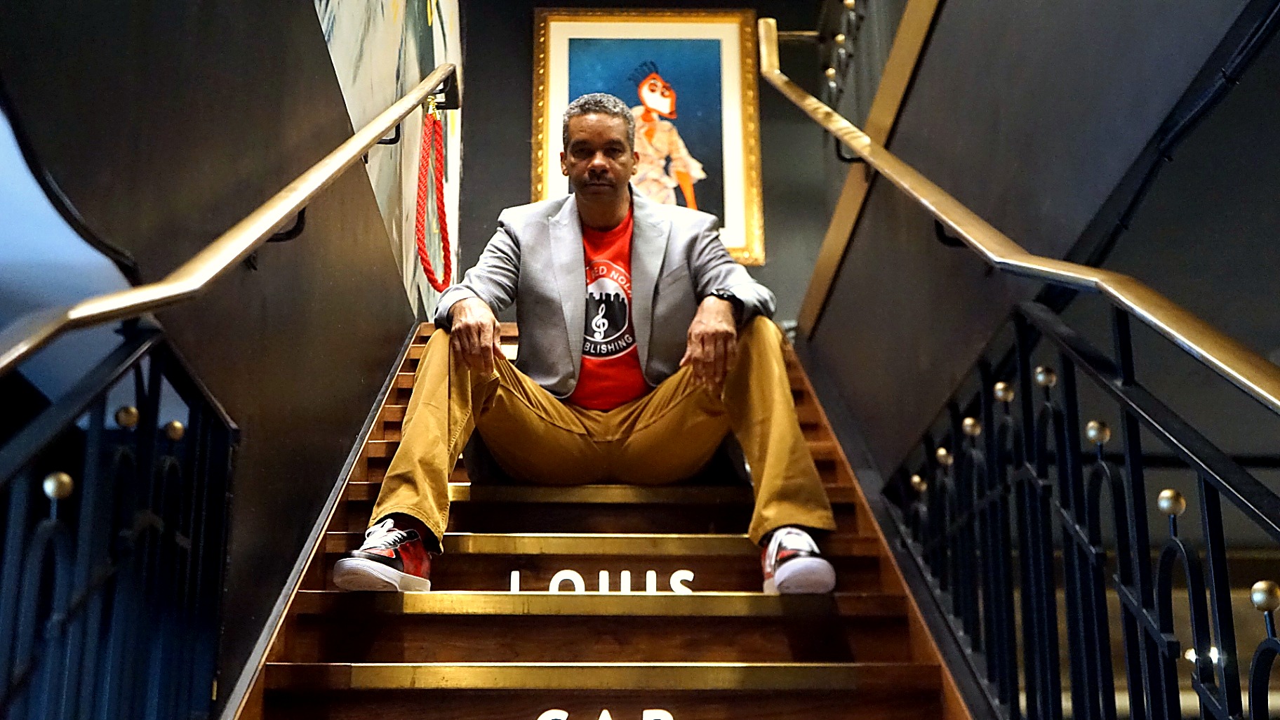 Cyril Darensbourg seated on the steps of the Louis Armstrong monument in New Orleans