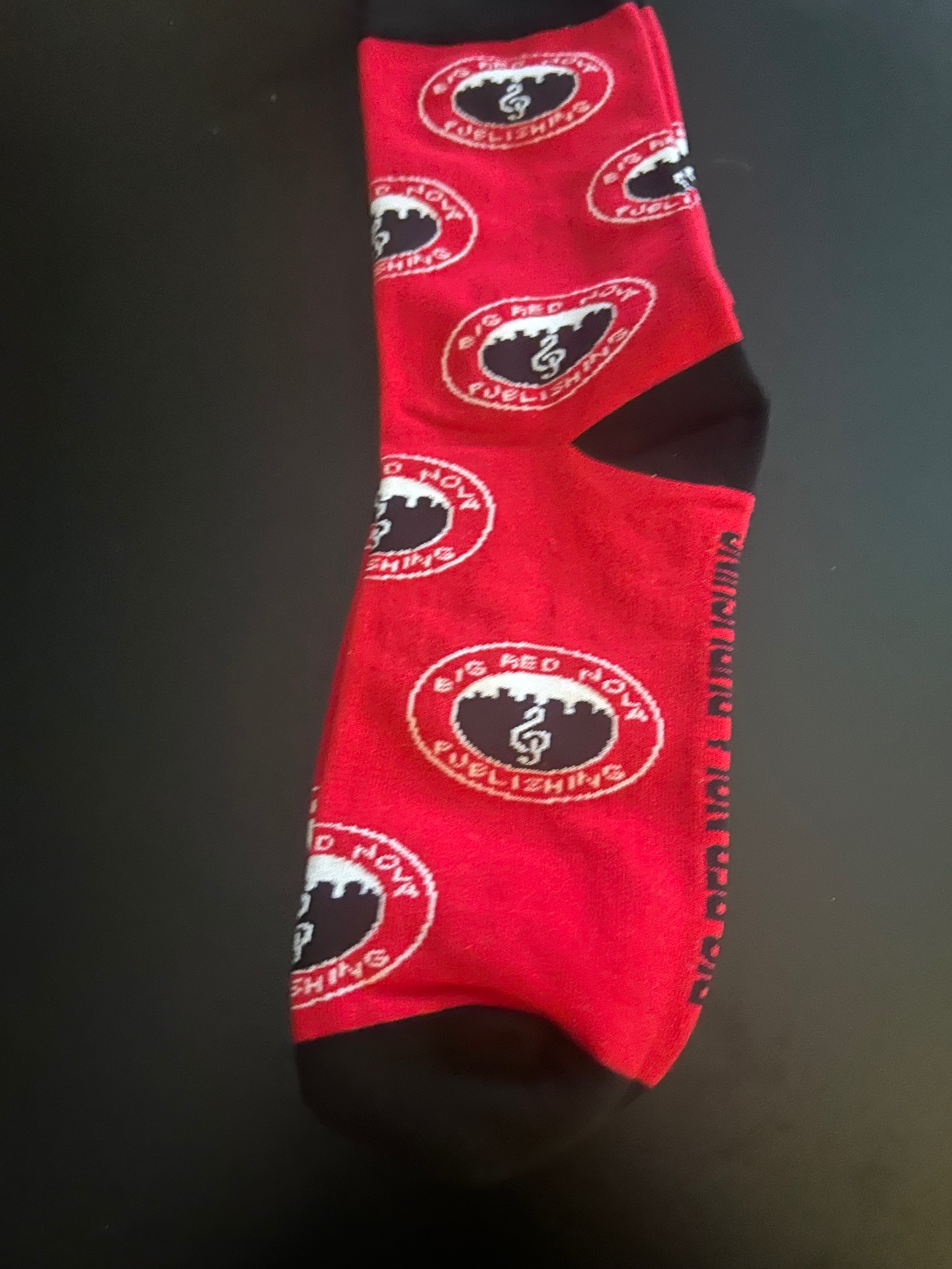 Big Red NOLA Publishing logo socks — red with all-over black-and-white BRN crest.