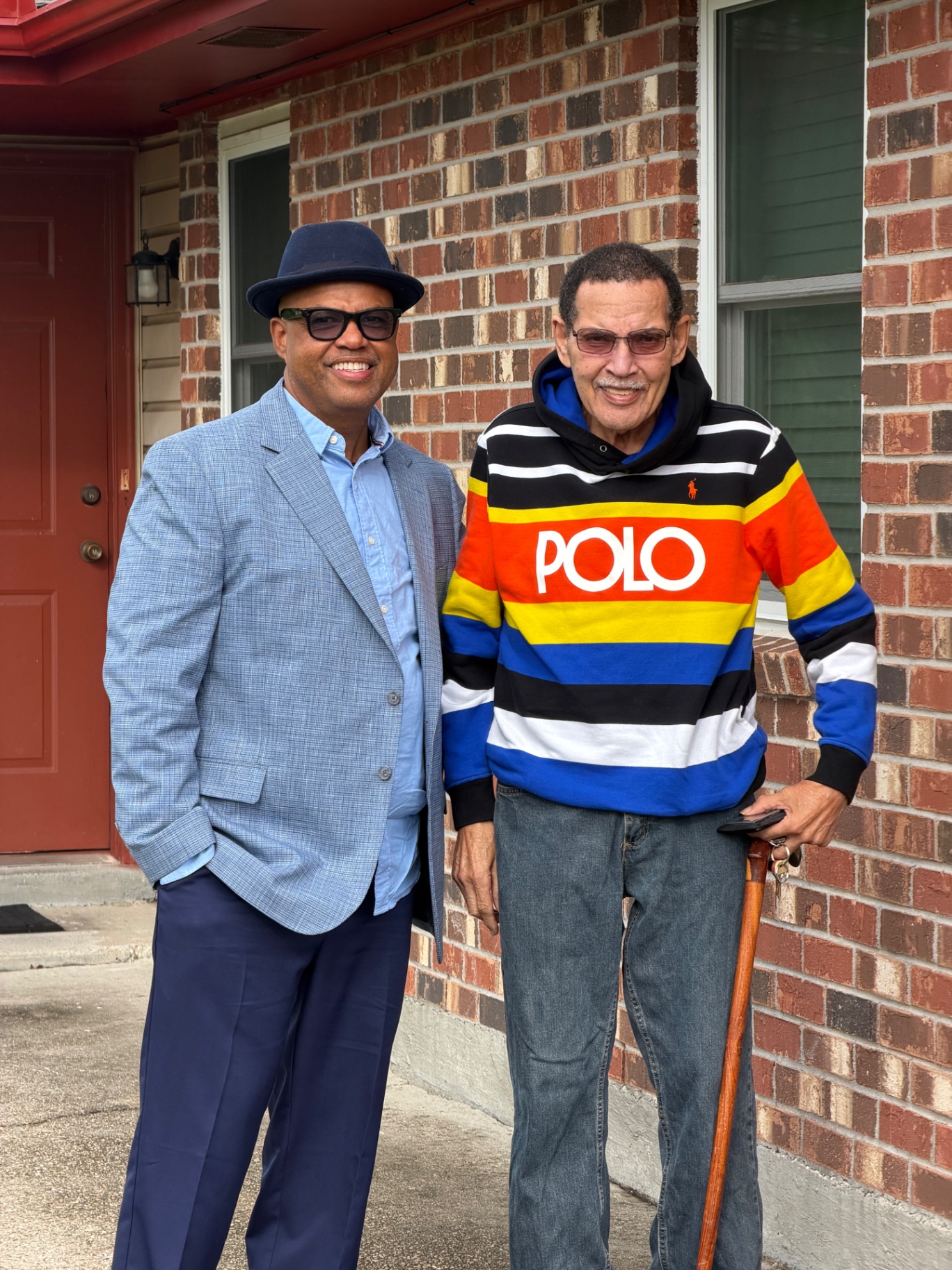 Dr. Jupiter's brother and father standing together outside the family home.