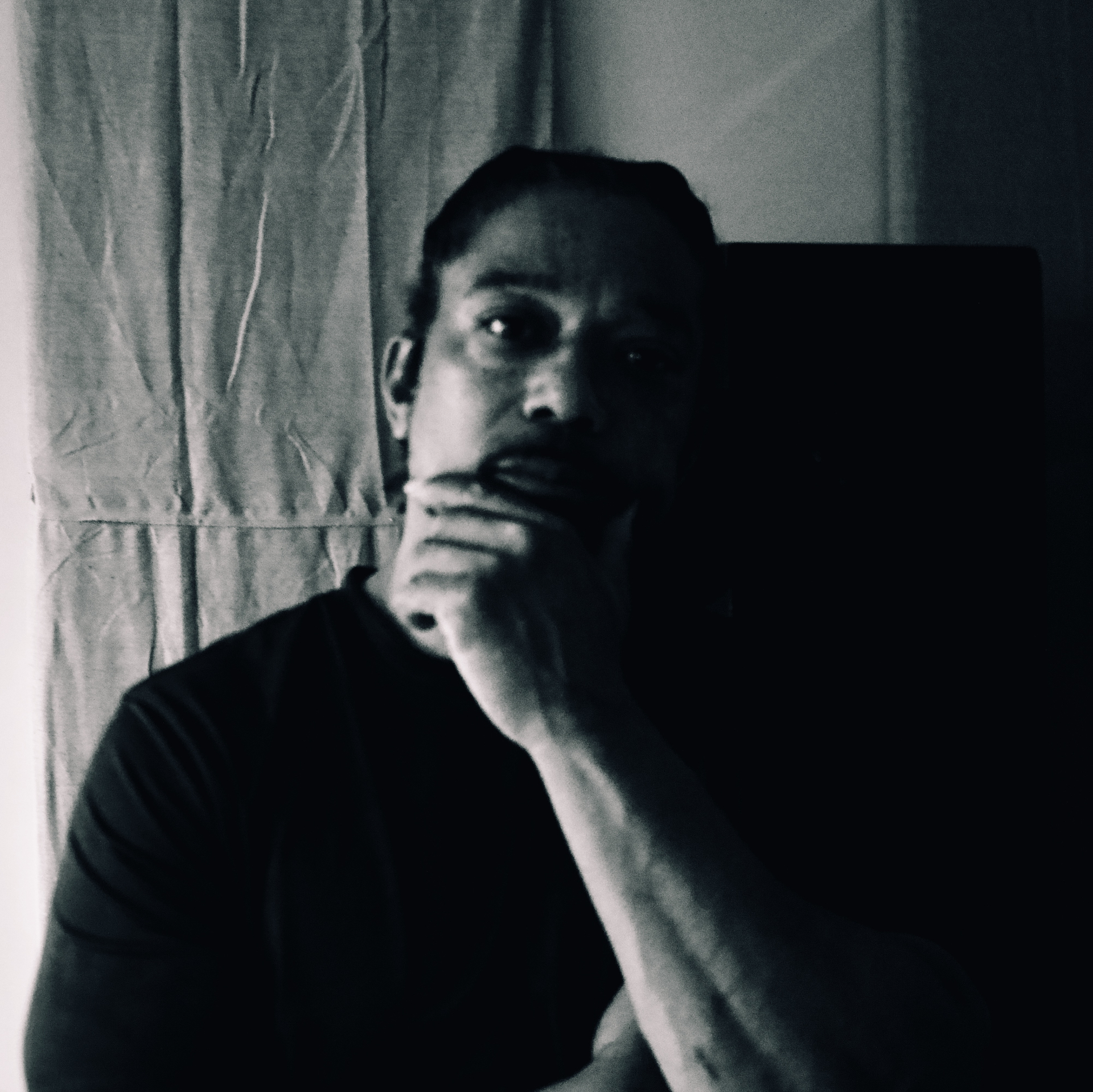 Black-and-white portrait — the host between questions, off-air.